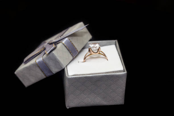 istock Golden ring with diamond in box isolated on black 1146444827