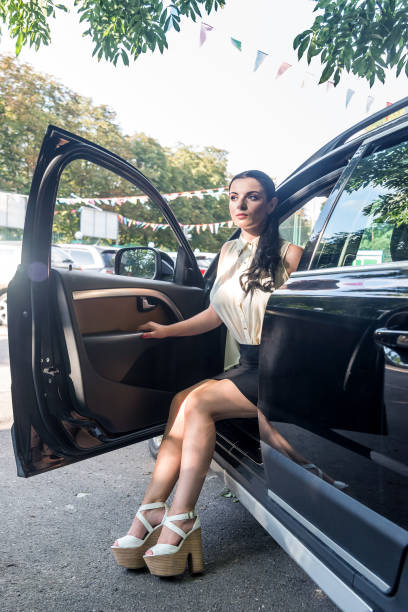 istock Beautiful brunette posing with car holding legs outside 1146445465