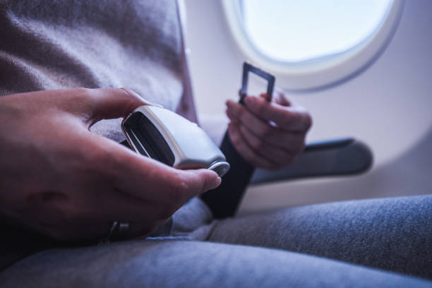 istock Female passenger fastening seat belt while sitting on the airplane for safe flight. 1146445527