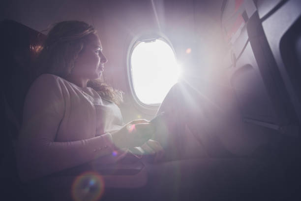 istock Young woman holding mobile and looking in view from airplane. 1146445581