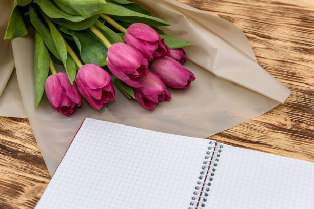 istock Open blank notepad and bouquet of pink tulip flowers 1146445663