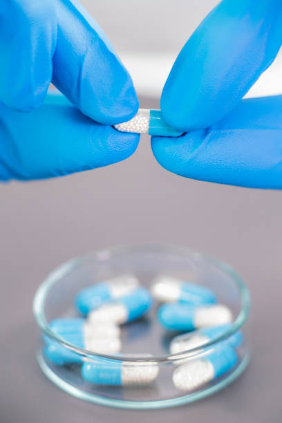 istock Doctor`s Hand Opening Pill Capsule above Petri Dish 1146446567