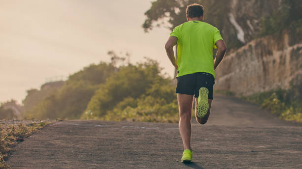 Man jogging on a downhill / uphill in suburb mountain road.