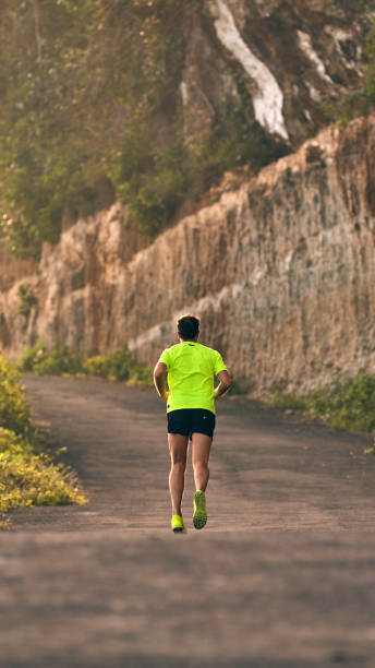 istock Man jogging on a downhill / uphill in suburb mountain road. 1146447818