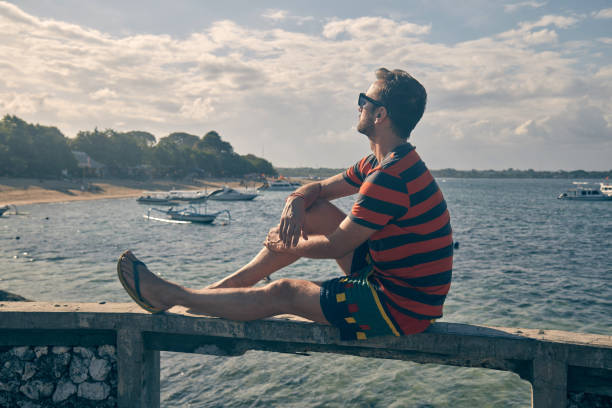 istock Man sitting at the ocean bay on a tropical island. 1146448309