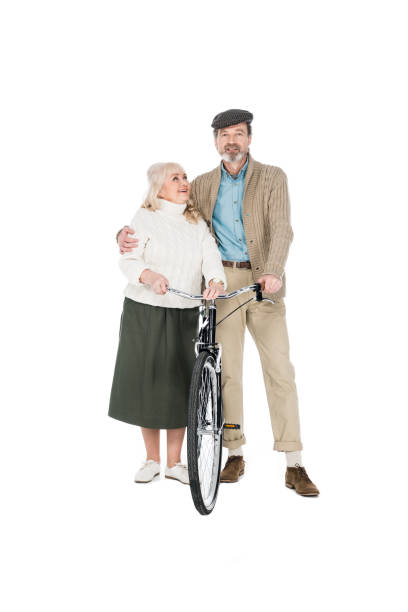 istock cheerful pensioner hugging happy wife while holding bicycle isolated on white 1146448742