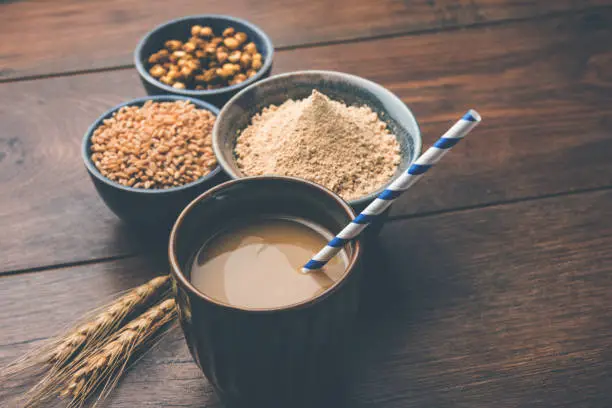 Sattu sharbat is a cooling sweet drink made in summer with roasted black chickpea flour, barley, suger, salt & water. served in a glass. selective focus