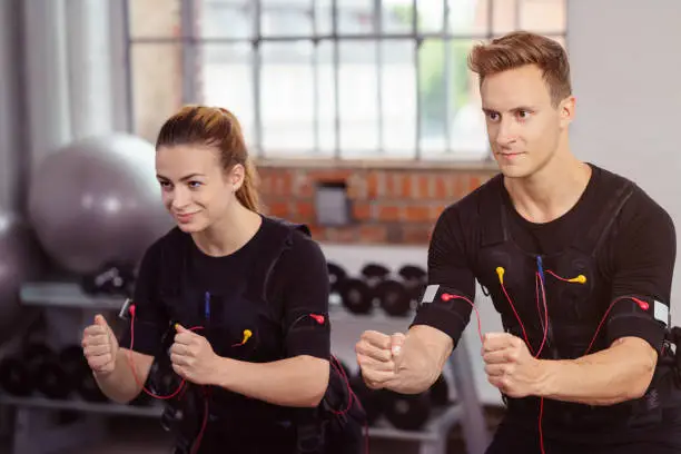 Male and female athlete wearing black workout top and strapped to heart monitors
