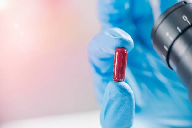 istock Scientist’s Hand in a Glove Holding an Red Pill 1146449709