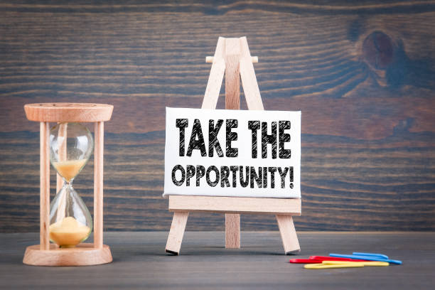 istock Take the opportunity. Sandglass, hourglass or egg timer on wooden table 1146450945