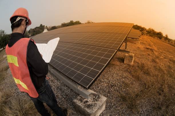 istock The worker in uniform and helmet checks Solar cell. 1146451475