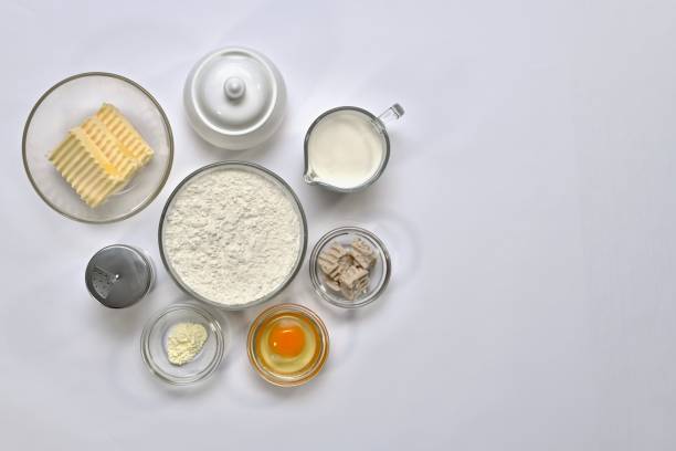 istock Ingredients for yeast dough. Each in a separate container: wheat flour, butter, egg, sugar, salt, yeast, milk, baking powder. 1146451485