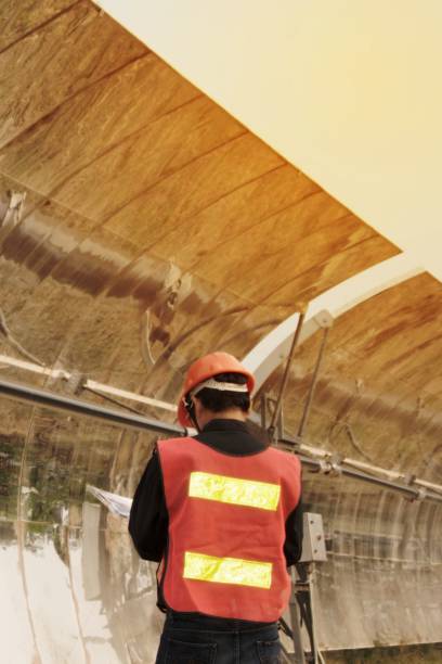 istock The worker in uniform and helmet checks Solar Parabolic Troughs. 1146452038