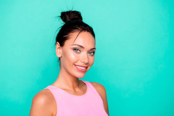 feche acima do perfil lateral foto bela incrível ela sua senhora bonita penteado olhar ouvir atentamente toothy ideal aparência desgaste casual rosa tank-top roupa roupas isoladas teal turquesa fundo - hair bun - fotografias e filmes do acervo