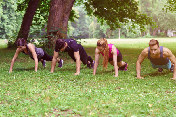 istock Two young couple working out in a park 1146452381
