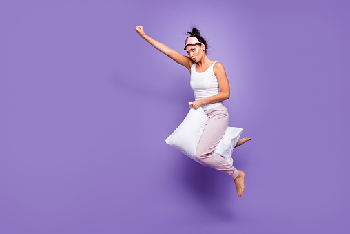 Full length side profile body size photo beautiful she her lady super power flight hold between legs pillow funny satisfied wear sleeping mask pants tank-top pajamas isolated violet purple background.