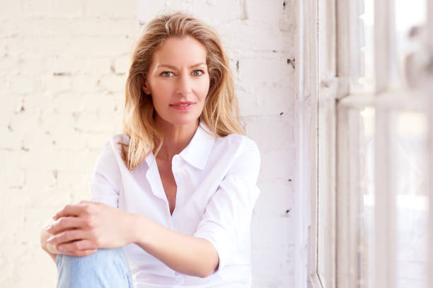 istock Attractive mature woman portrait while relaxing at the window 1146453579