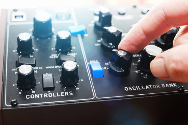 istock Hand adjusting controls of retro-style analog synthesizer 1146453959
