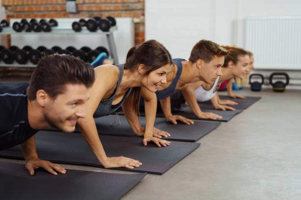 istock Men and women on yoga mats do push ups 1146454721