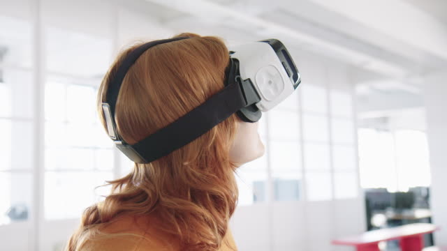 Businesswoman using VR headset at her work place