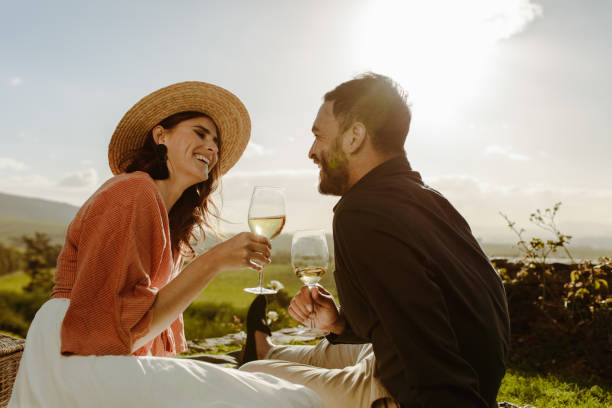 istock Couple sitting near a vineyard on a date drinking wine 1146455957