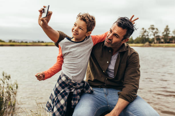 istock Father and son having fun taking selfie outdoors 1146456206