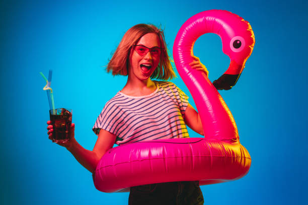 istock Beautiful woman in neon light isolated on blue studio background 1146458492