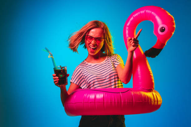 istock Beautiful woman in neon light isolated on blue studio background 1146458499
