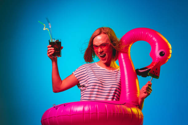 istock Beautiful woman in neon light isolated on blue studio background 1146458526