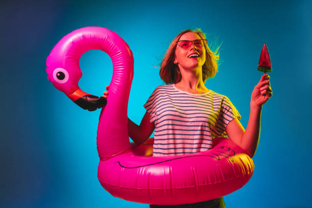 istock Beautiful woman in neon light isolated on blue studio background 1146458529