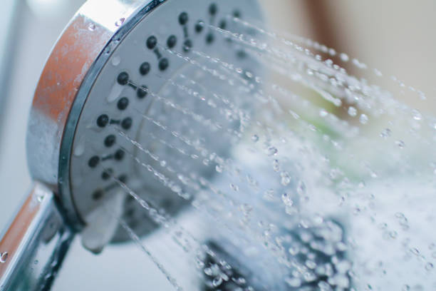 istock Image of a modern shower head splashing water close up background 1146458580