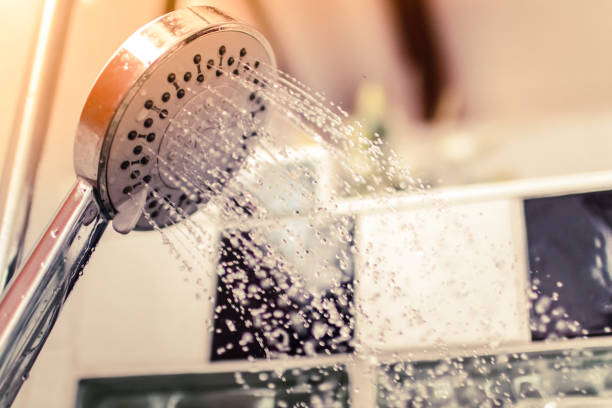 Image of a modern shower head splashing water close up background