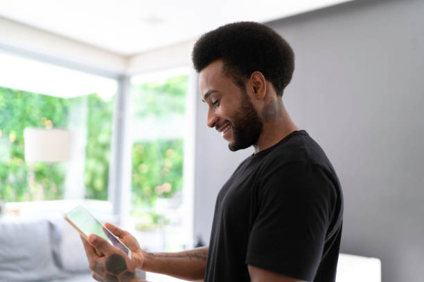 istock Man using digital tablet for control the home automation at home 1146458914
