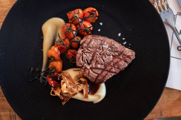 istock Beef tenderloin with rustic mashed potatoes, roasted cherrys and confit garlic sauce on dark plate 1146460078