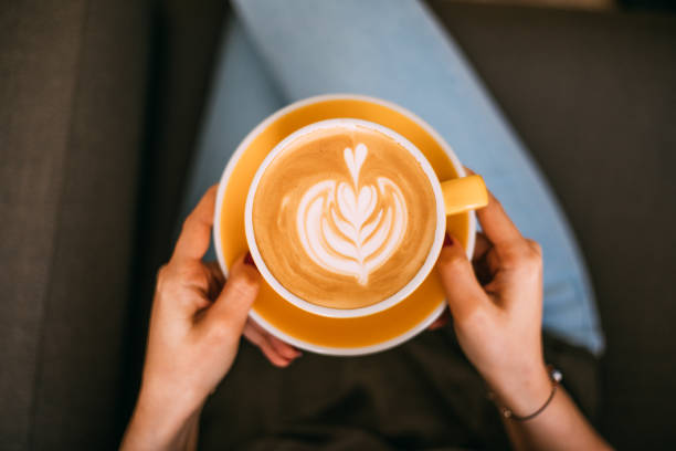 istock Lady's hands holding cup with latte art 1146465600