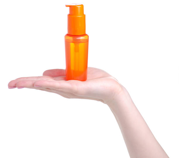 istock Orange sunscreen suntan bottle in hand 1146467099