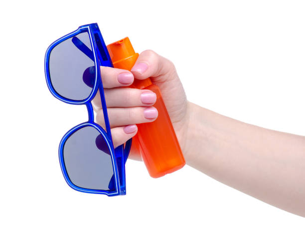 istock Orange sunscreen suntan bottle and sunglasses in hand 1146467112
