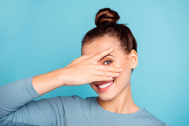 close up photo beautiful she her lady arm hand fingers raised hide half face toothy beaming smile cute nice-looking friendly enjoy day off wear casual sweater pullover isolated blue bright background - half smile imagens e fotografias de stock