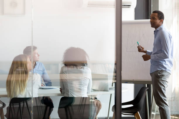 istock African coach mentor speaker give flipchart presentation at corporate meeting 1146468262