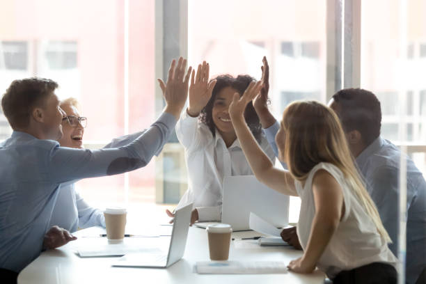 Happy multicultural executive team people give high five celebrate success Happy multicultural executive team people give high five, diverse motivated office employees group engaged in teambuilding spirit promise trust integrity celebrate shared business success win concept high fidelity stock pictures, royalty-free photos & images