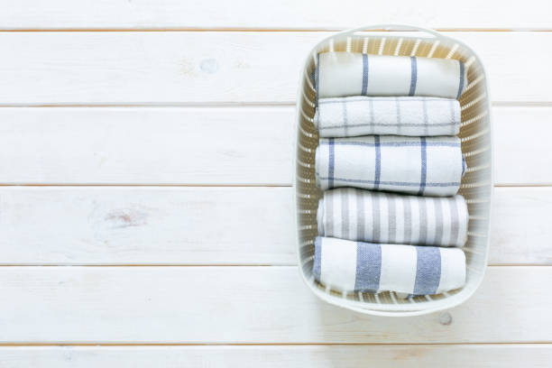 Clean kitchen towels stacked in a basket on the basket, selective focus