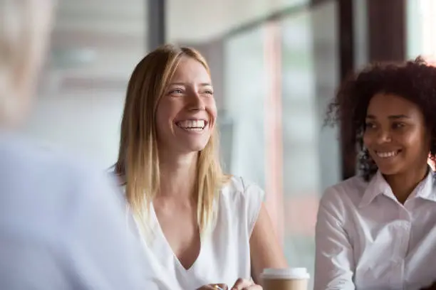 Photo of Happy young businesswoman coach mentor leader laughing at group meeting