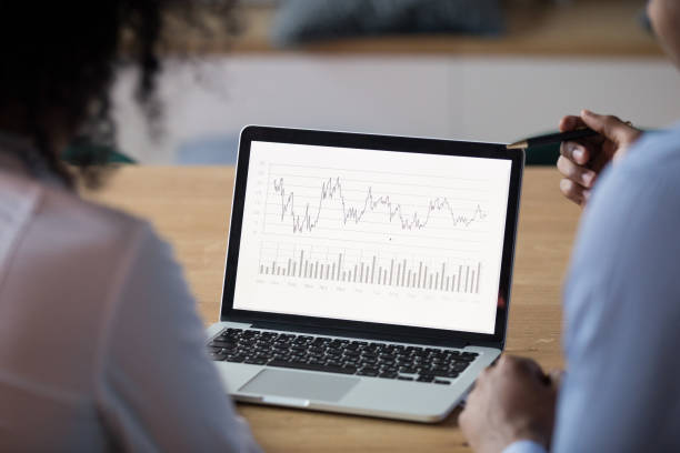 istock Rear view at african analysts analyze financial report on laptop 1146468342