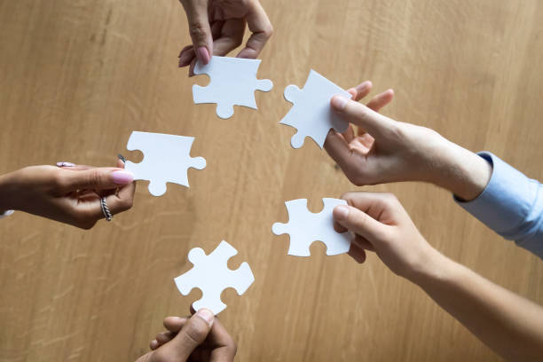 istock Hands of multiethnic associate partners employees holding puzzle pieces 1146468354
