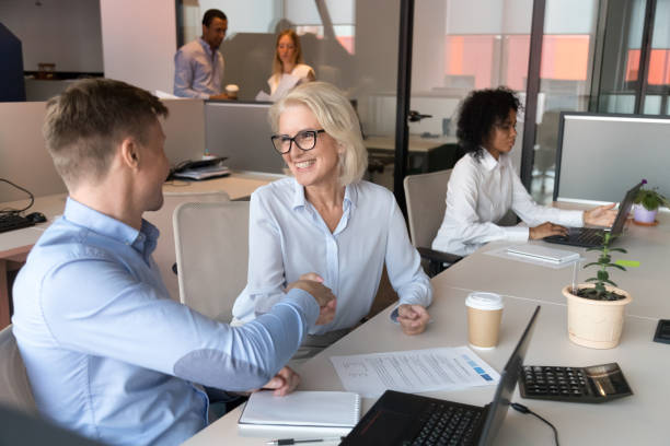 istock Happy designers colleagues old manager and employee handshake at workplace 1146468373
