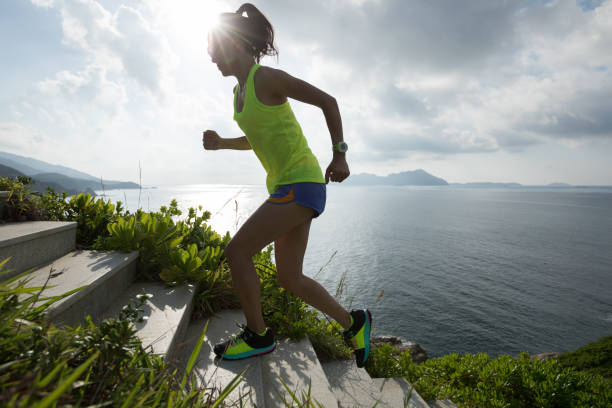 istock Determined woman running up on seaside mountain stairs 1146470410