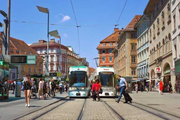 public Tram train at the front of vintage buiding with many of people around in Graz district city center, Austria stock photo