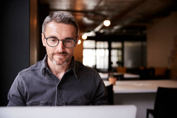 istock Middle aged white male creative sitting in an office looking at laptop computer screen, close up 1146471441
