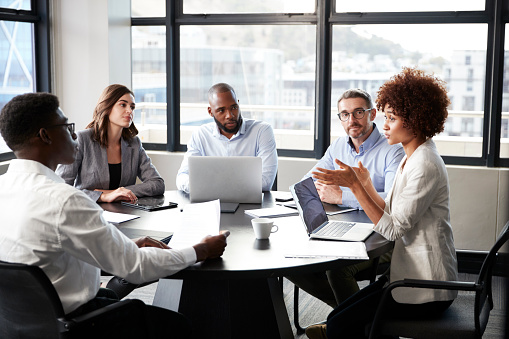 Empresaria negra Millennial dirigiéndose a sus colegas en una reunión de negocios corporativos, de cerca photo