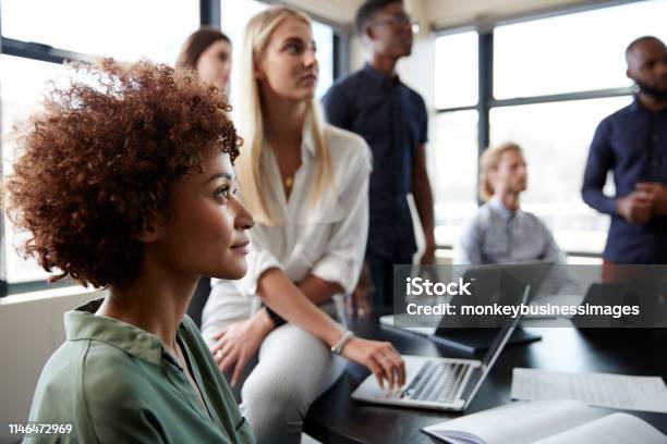 Close Up Of Creative Business Colleagues Listening To An Informal Presentation In A Meeting Room Stock Photo - Download Image Now